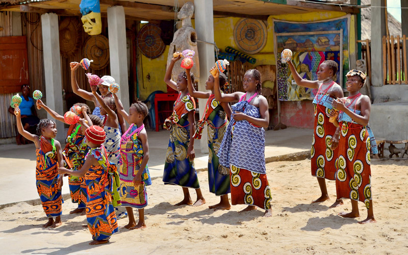 A group of african women and little girls dancing