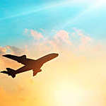 Airplane in the sky with clouds at sunset.