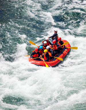 Group of men and women rafting on a river.
