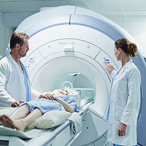 Doctors preparing a patient for MRI scan in hospital.