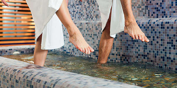 Homme et femme entrain de profiter du bien-être de l'eau ou de l'hydrothérapie, seuls les pieds sont visibles