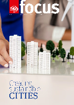 Architect woman's hand holding buildings models on a conference table.